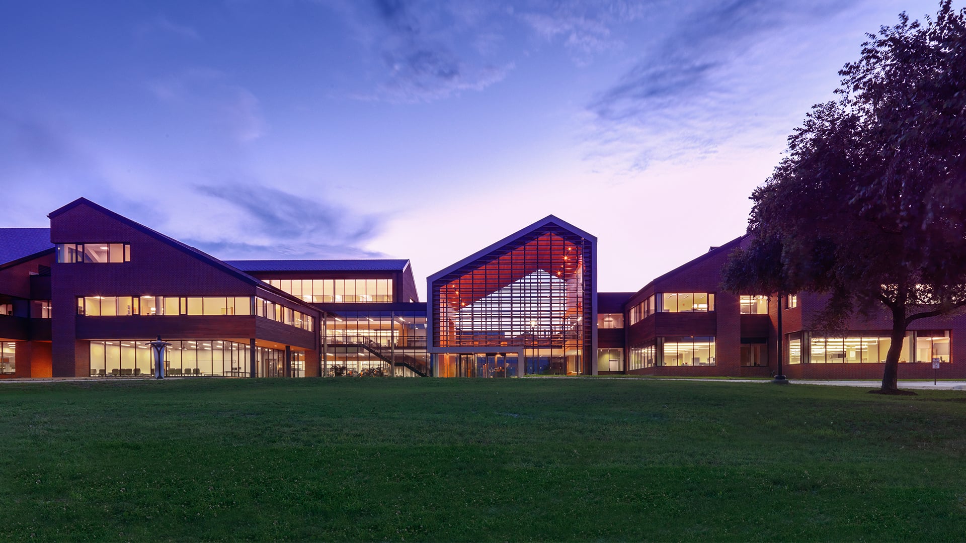 exterior of lit up college with sky at dusk